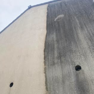 A rendered gable wall half cleaned, showing the contrast A rendered gable wall half cleaned, showing the contrast